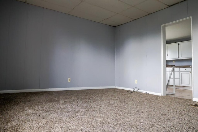 carpeted spare room featuring a paneled ceiling