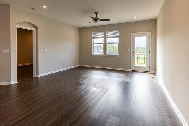 unfurnished room with recessed lighting, arched walkways, ceiling fan, and dark wood-style floors