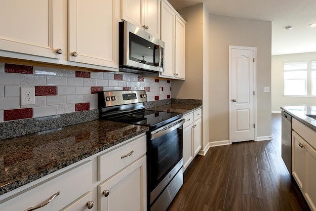 kitchen with dark stone counters, appliances with stainless steel finishes, tasteful backsplash, and dark wood-style floors