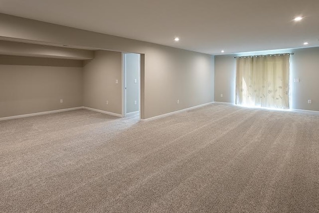 basement featuring recessed lighting, baseboards, and light colored carpet