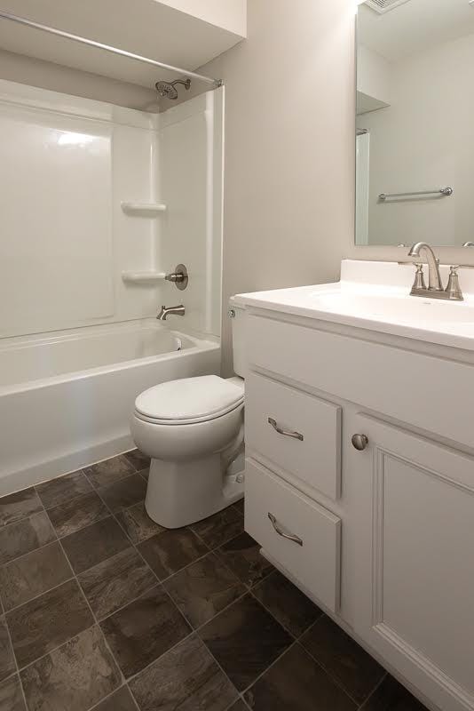 bathroom with toilet, shower / washtub combination, and vanity