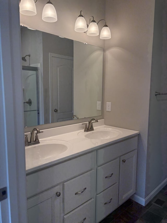 full bathroom with a sink, tile patterned floors, walk in shower, and double vanity