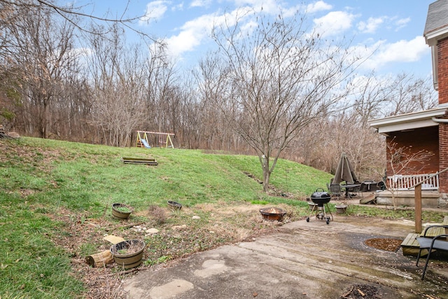 view of yard featuring a playground and a patio