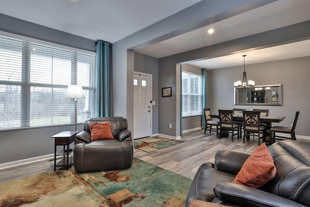 living room featuring a wealth of natural light, a chandelier, and hardwood / wood-style flooring