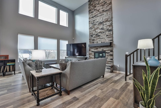 living room featuring a fireplace, light wood-type flooring, and a healthy amount of sunlight