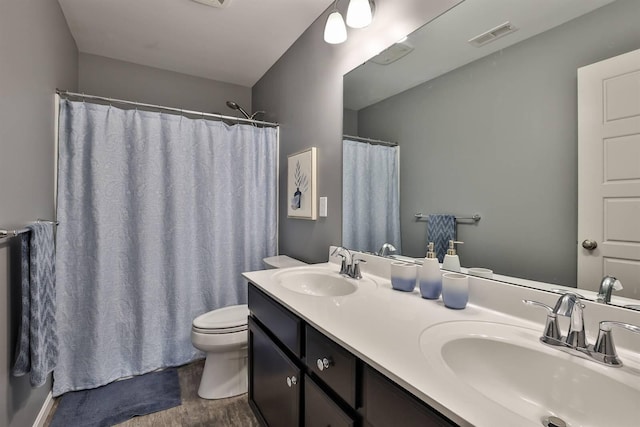 bathroom with toilet, walk in shower, hardwood / wood-style flooring, and vanity