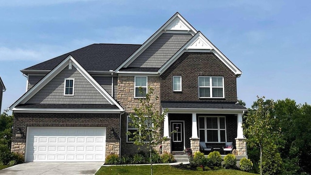 craftsman house with a garage, a front lawn, and a porch