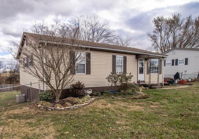 rear view of house featuring a yard