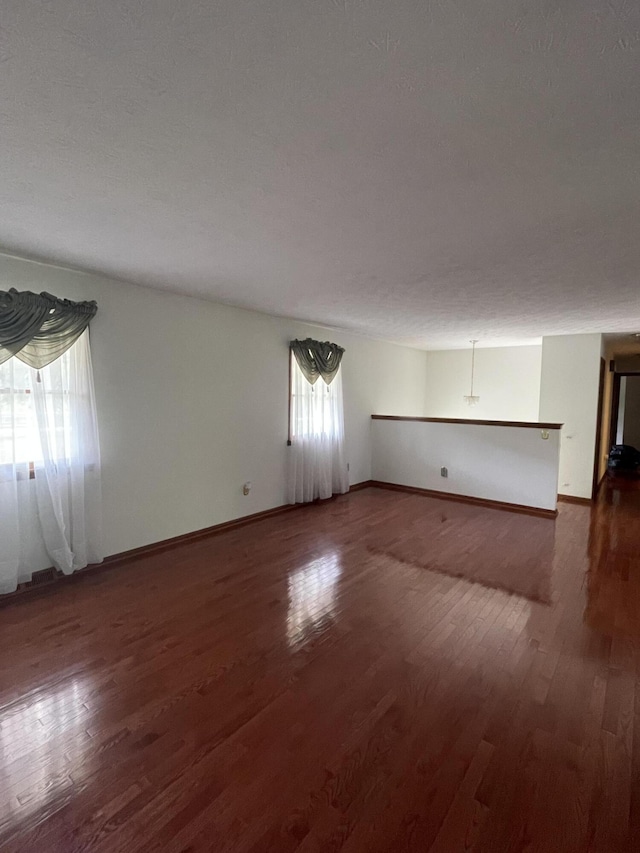 unfurnished room featuring dark hardwood / wood-style floors and a textured ceiling