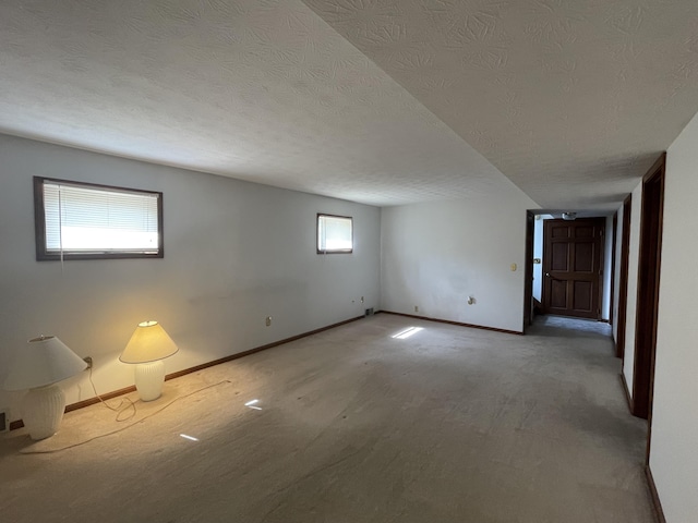 carpeted spare room with a textured ceiling