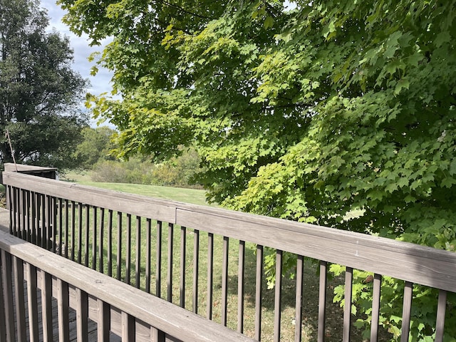 wooden deck featuring a lawn