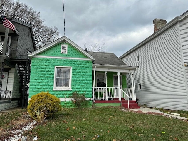 rear view of house with a yard and covered porch