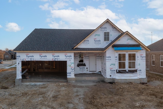 property under construction with a garage and roof with shingles