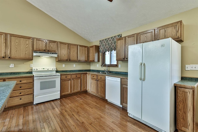 kitchen featuring lofted ceiling, light hardwood / wood-style floors, white appliances, and sink