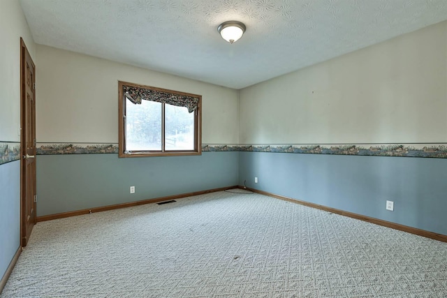 carpeted spare room with a textured ceiling