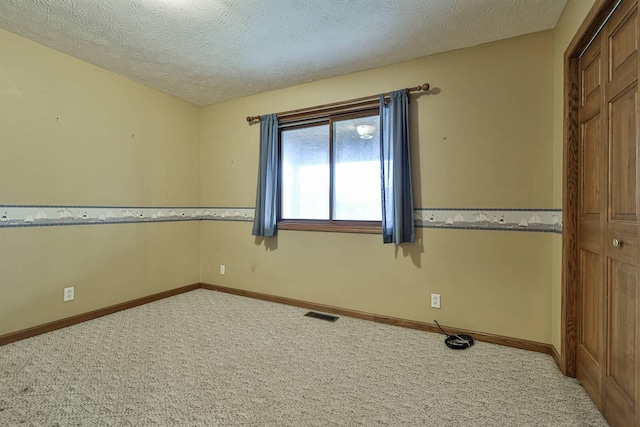 spare room with carpet and a textured ceiling