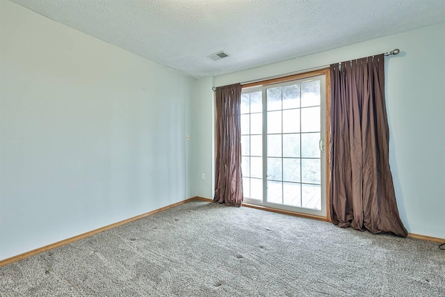 carpeted empty room featuring a textured ceiling