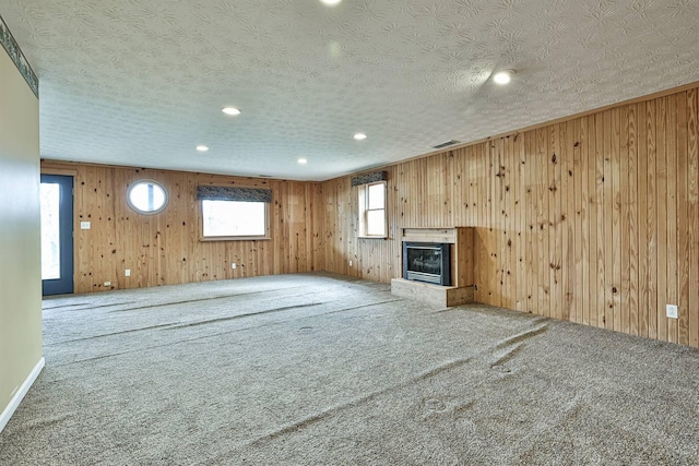 unfurnished living room featuring carpet flooring and a textured ceiling