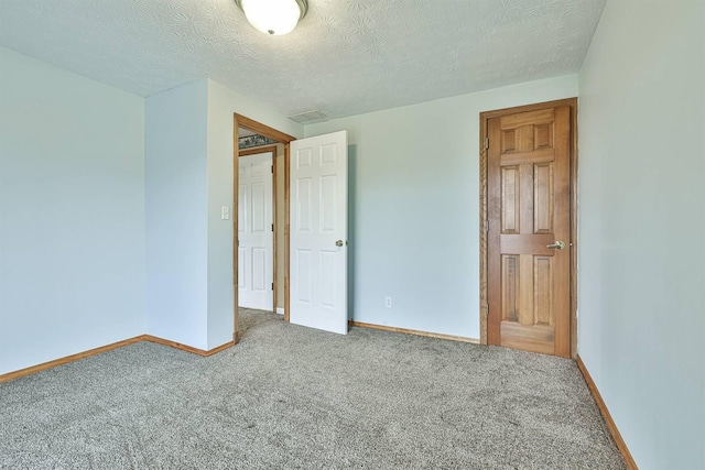 unfurnished bedroom featuring carpet flooring and a textured ceiling