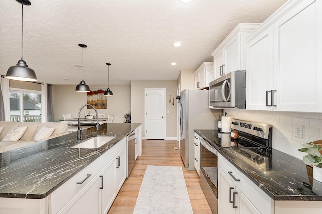 kitchen featuring backsplash, sink, hanging light fixtures, a large island, and stainless steel appliances