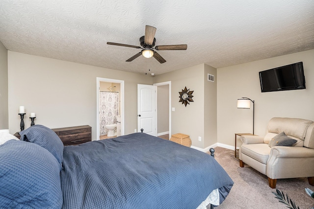 carpeted bedroom with ceiling fan, ensuite bathroom, and a textured ceiling