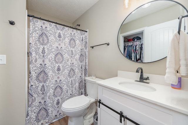 bathroom featuring vanity, hardwood / wood-style floors, a textured ceiling, and toilet