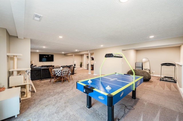 recreation room with carpet floors and a textured ceiling