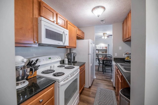 kitchen featuring ceiling fan, sink, dark hardwood / wood-style floors, a textured ceiling, and white appliances