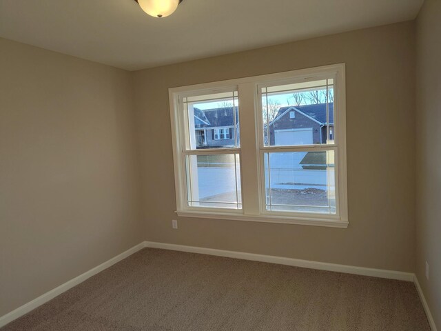 empty room with carpet and baseboards