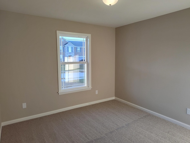 spare room featuring carpet flooring and baseboards