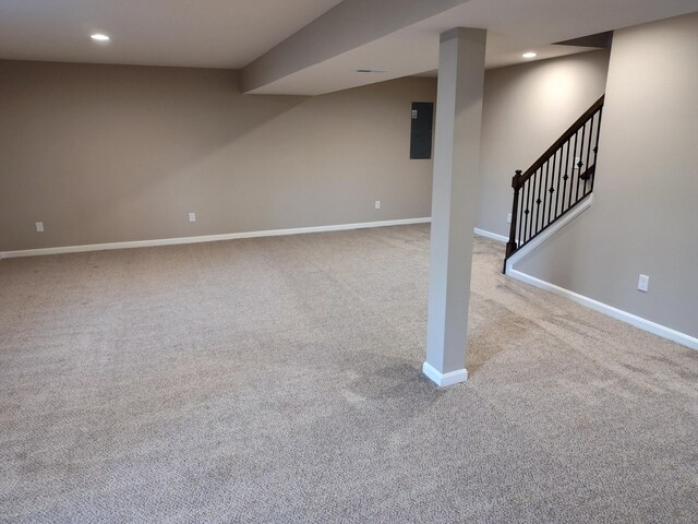 finished basement with recessed lighting, light colored carpet, baseboards, stairs, and electric panel