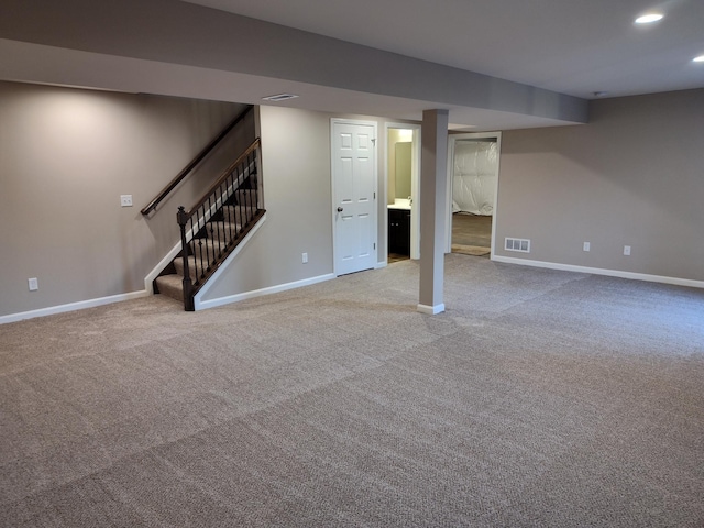 finished basement with stairs, baseboards, visible vents, and recessed lighting