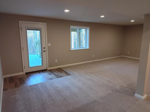 doorway to outside featuring light carpet, baseboards, and recessed lighting