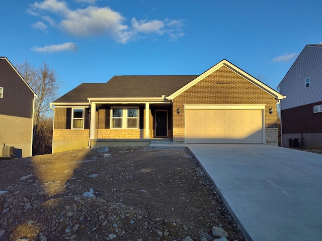 view of front of house with covered porch, cooling unit, and a garage