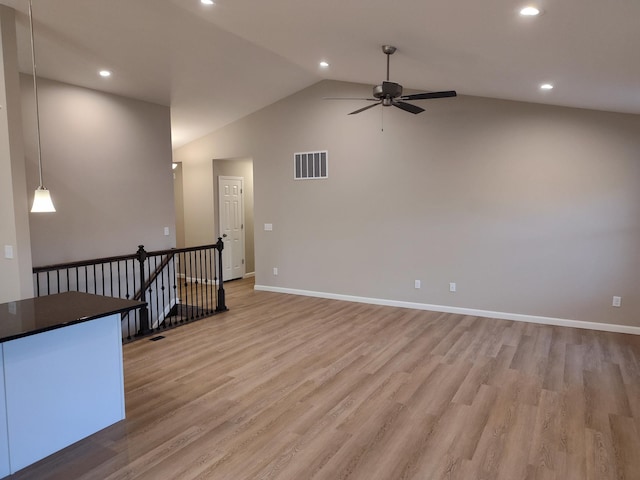 empty room with recessed lighting, visible vents, baseboards, vaulted ceiling, and light wood finished floors