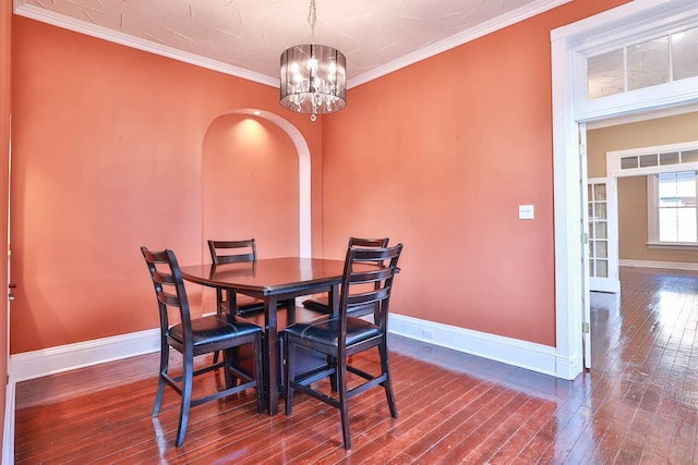 dining room featuring ornamental molding, a notable chandelier, and dark hardwood / wood-style floors