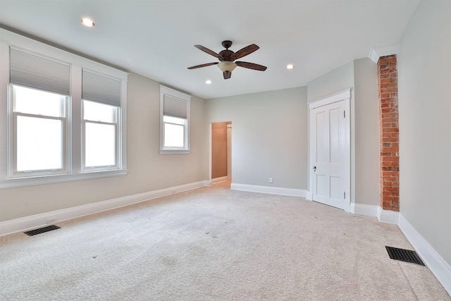 empty room with ceiling fan and light colored carpet