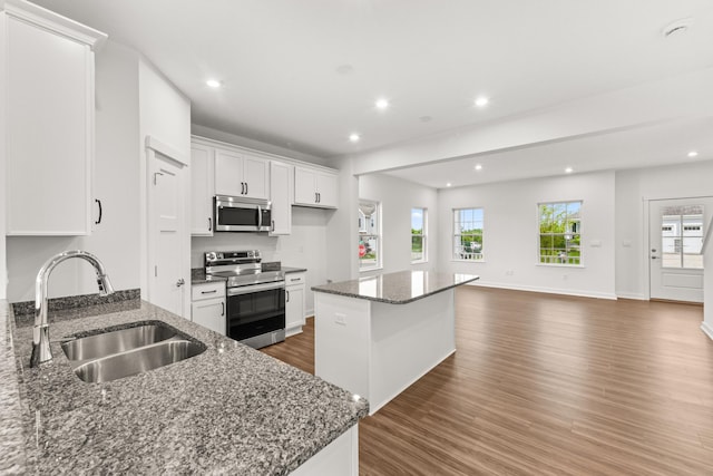 6566 Cannondale Dr, Burlington, KY 41005 - kitchen featuring appliances with stainless steel finishes, a sink, dark wood-style floors, white cabinetry, and a kitchen island