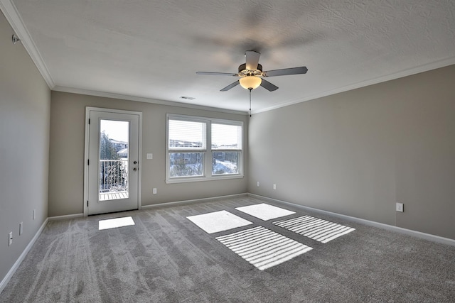 carpeted empty room featuring ceiling fan, crown molding, and a textured ceiling