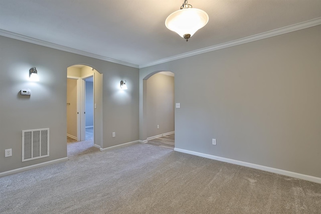 empty room featuring crown molding and light carpet