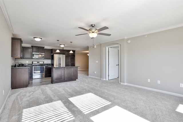 kitchen featuring decorative light fixtures, dark brown cabinets, light carpet, appliances with stainless steel finishes, and a kitchen island