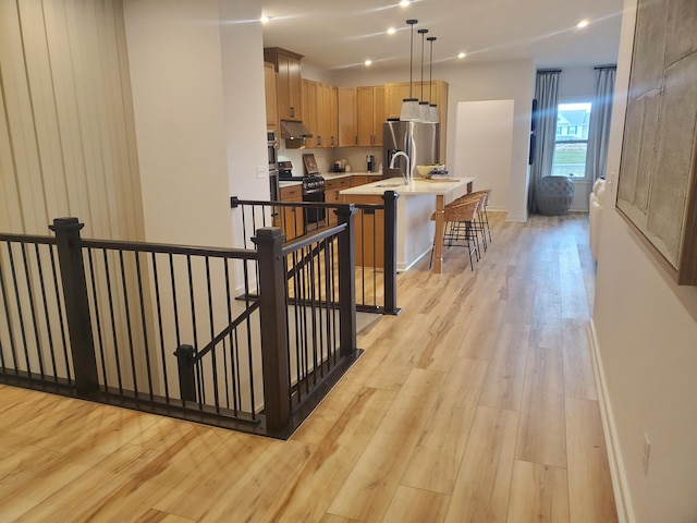 stairs with sink and hardwood / wood-style flooring