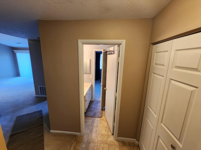 hall featuring a textured ceiling