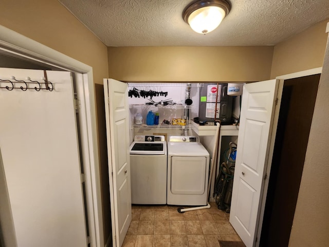 laundry room with separate washer and dryer and a textured ceiling