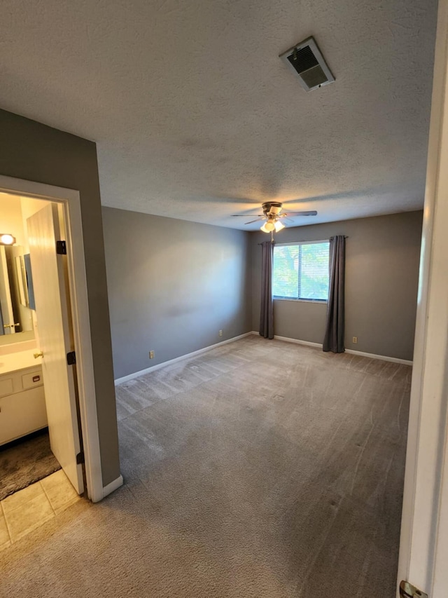 unfurnished room featuring light carpet, a textured ceiling, and ceiling fan