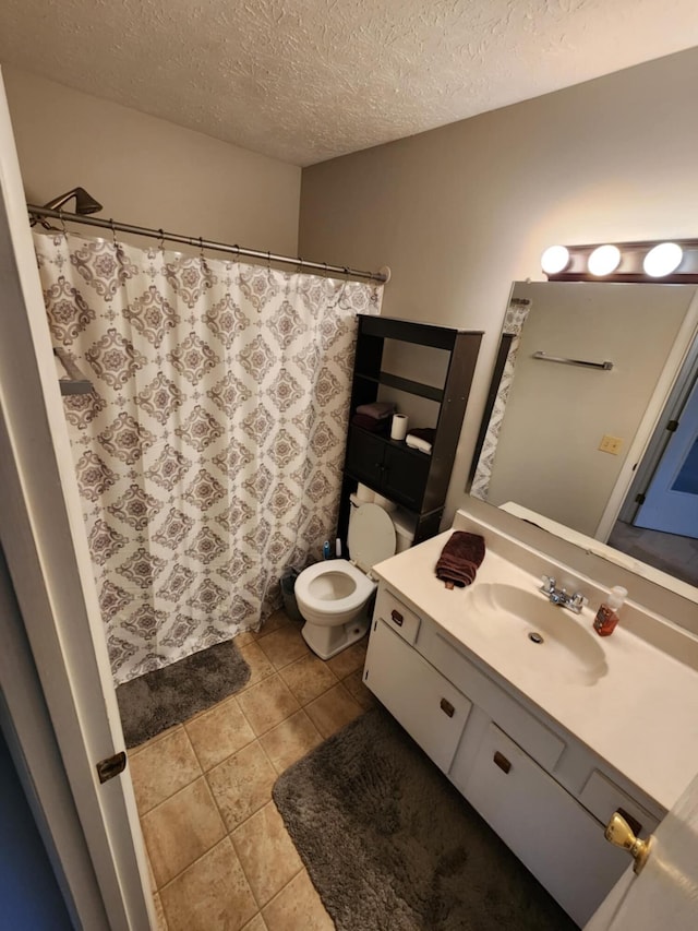 bathroom with vanity, a textured ceiling, and toilet