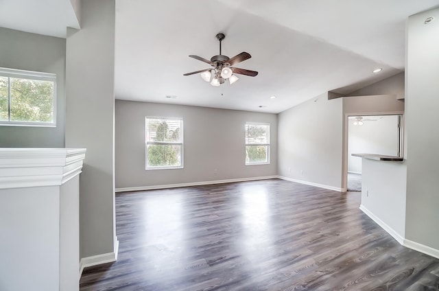 unfurnished living room with plenty of natural light, dark hardwood / wood-style floors, lofted ceiling, and ceiling fan