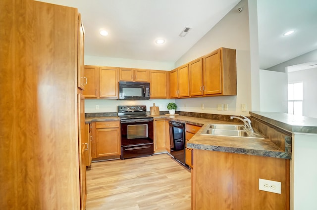 kitchen with kitchen peninsula, light wood-type flooring, vaulted ceiling, and black appliances