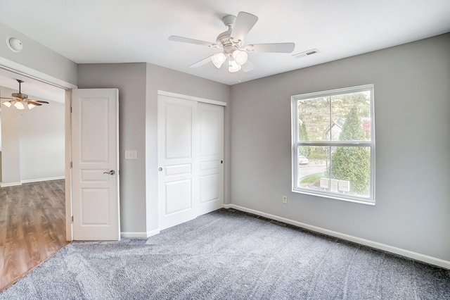 unfurnished bedroom with carpet, ceiling fan, and a closet