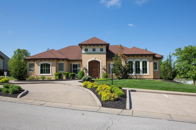 mediterranean / spanish-style home with a front lawn